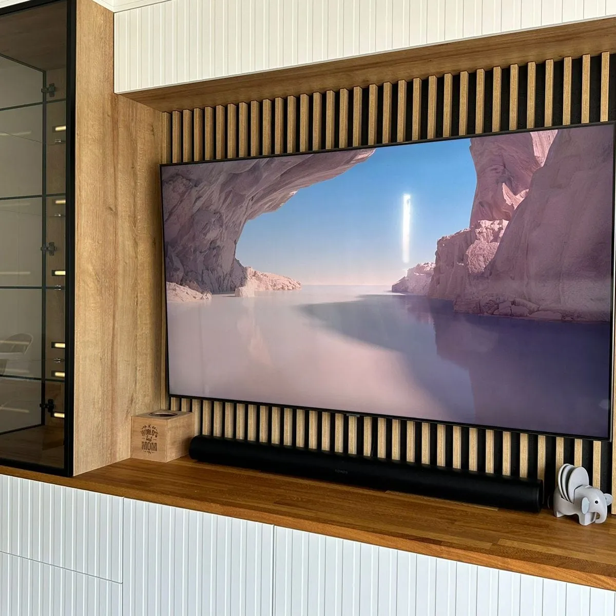Oak slatted media wall with a built-in glass display cabinet