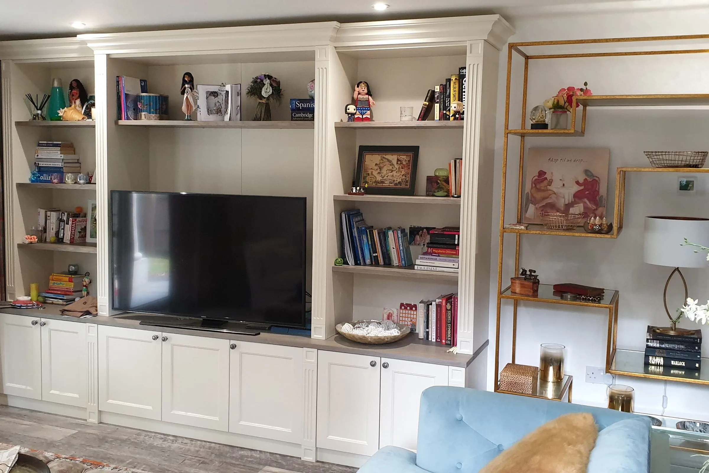 Cream painted bookcase and TV unit with open shelves and cupboards below