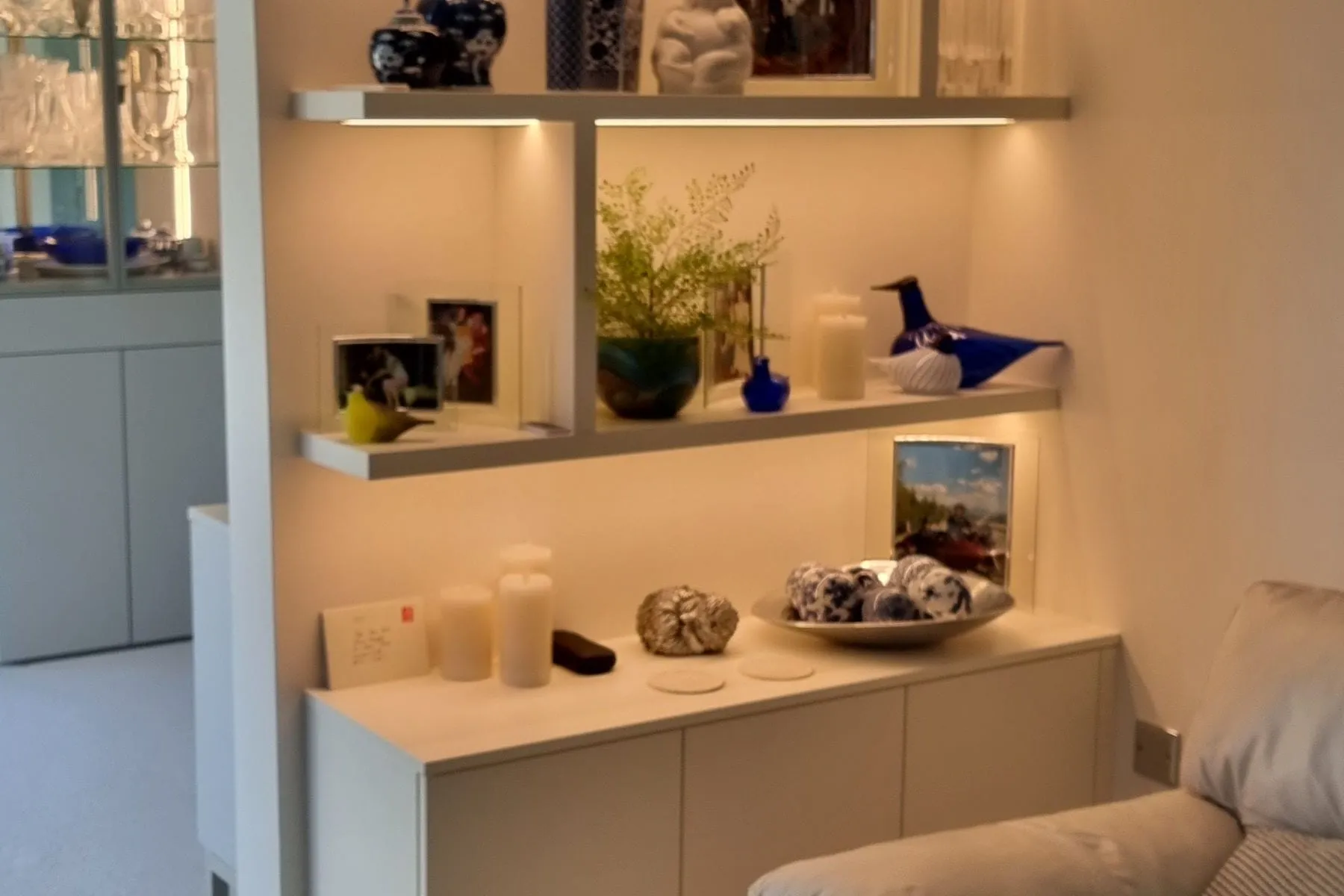 Floating lit shelves above a low cabinet in a fitted study