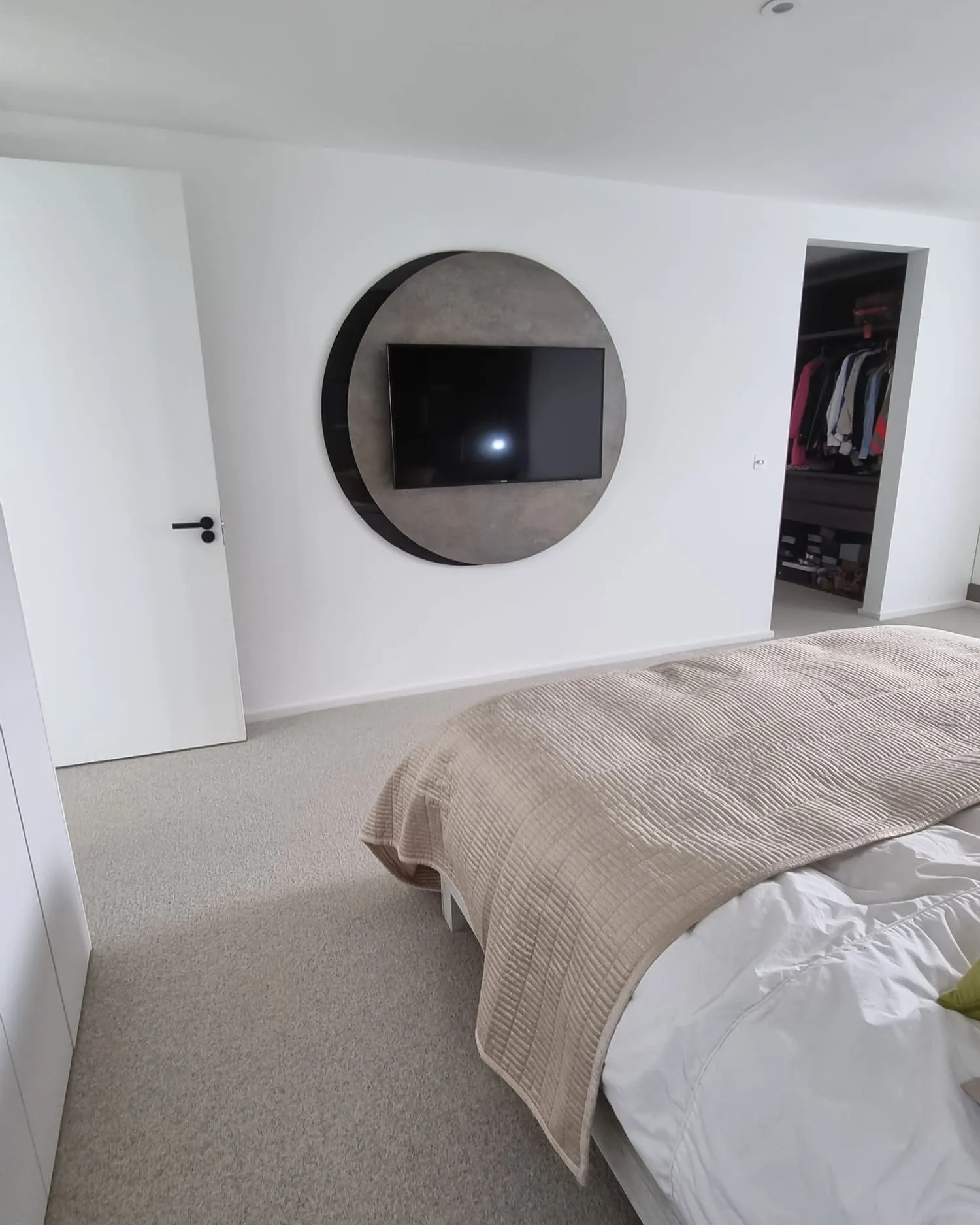 Circular TV feature set into a plastered bedroom wall
