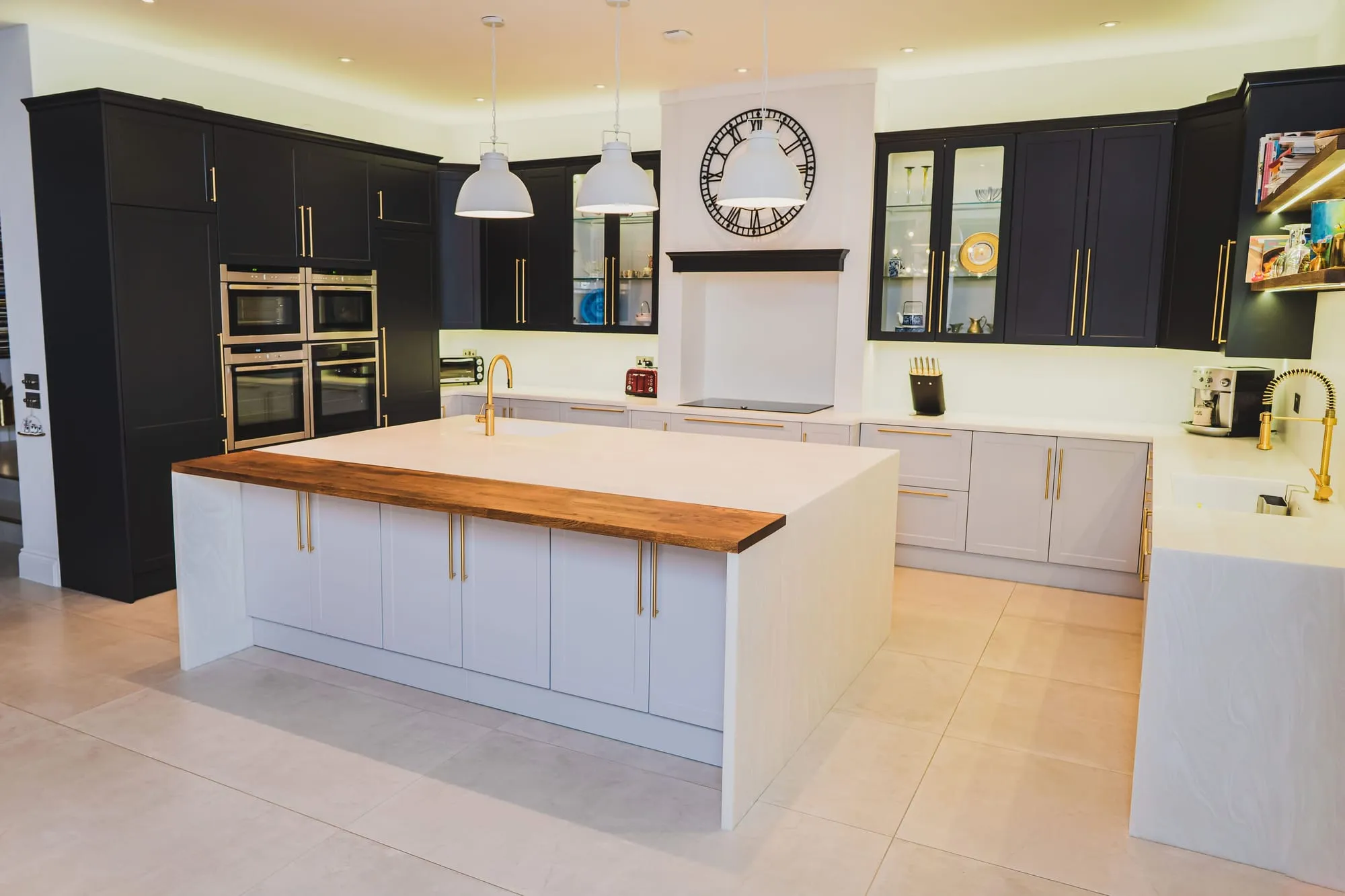 Navy shaker kitchen with an oak-topped island and brass handles