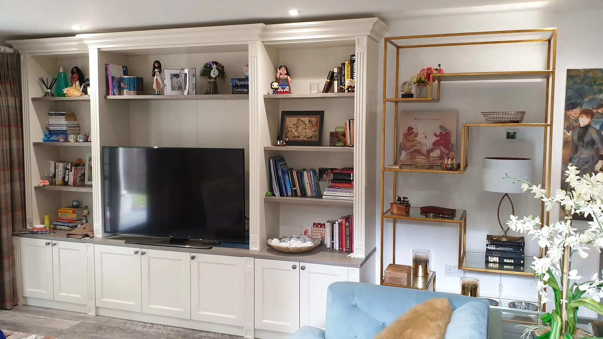 Cream painted bookcase and TV unit with open shelves and cupboards below