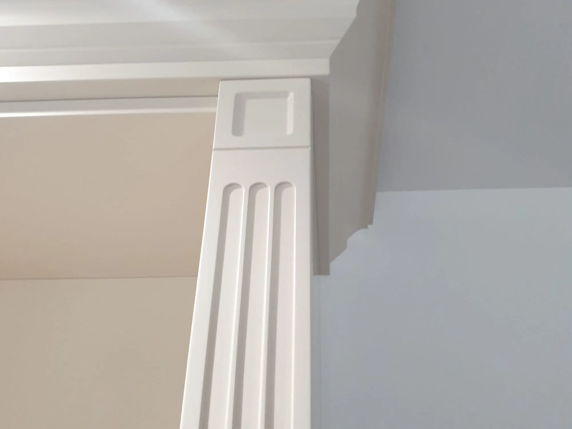 Fluted pilaster and cornice detail on a painted fitted unit